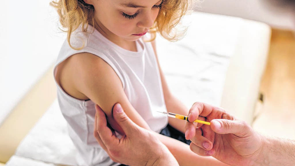 Close-up of a sweet blond boy and a doctor with a syringe Impfen