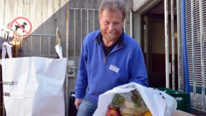 Karsten Böhm mit den Lebensmitteltüten bei der Ausgabe