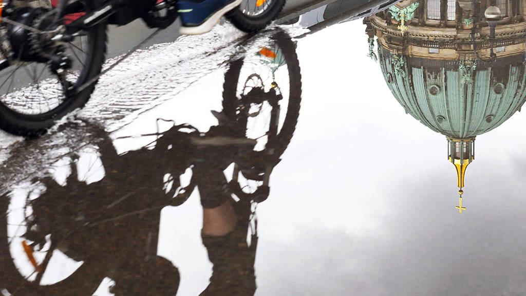 Radfahrer spiegelt sich in einer Pfütze