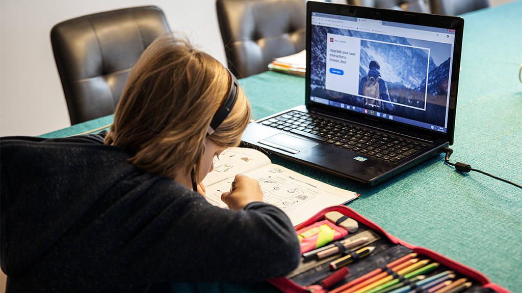 Bamberg, Deutschland 20. Januar 2021: Ein Grundschulkind mit Headset, sitzt in einem Wohnzimmer am Tisch und macht Homes