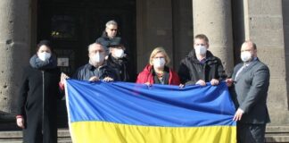 Die Mitglieder des Bezirksamts versammeln sich hinter einer ukrainischen Flagge. Bild: Bezirksamt Tempelhof-Schöneberg