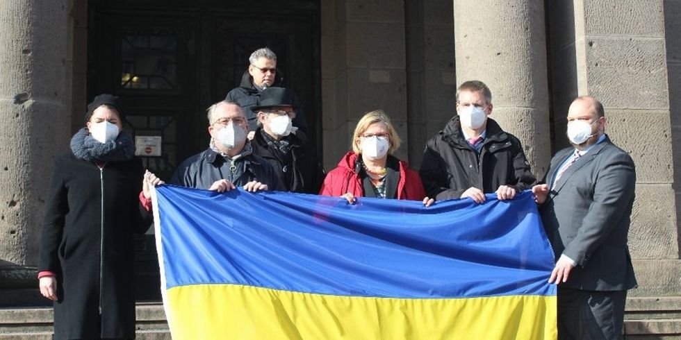 Die Mitglieder des Bezirksamts versammeln sich hinter einer ukrainischen Flagge. Bild: Bezirksamt Tempelhof-Schöneberg