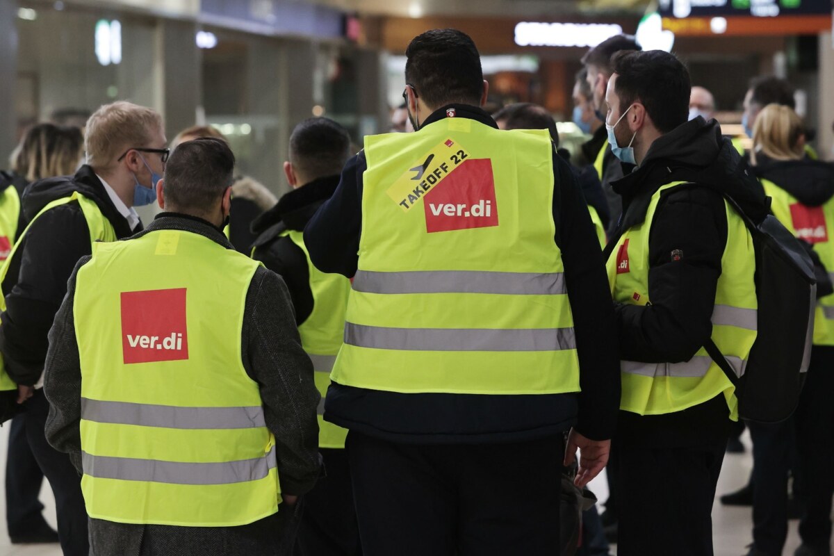 Eine Gruppe Streikender mit gelbe Ver.di-Westen steht im Köln-Bonn-Airport.