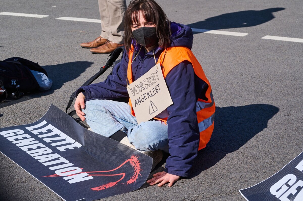 Klimaaktivisten der Initiative "Letzte Generation" sitzen, teilweiße mit festgeklebten Händen auf der Ebertstraße vor dem Brandenburger Tor und demonstrieren.