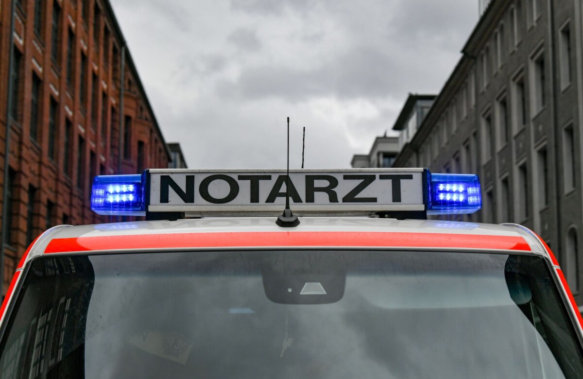 Ein Notarztwagen steht mit eingeschaltetem Blaulicht auf der Straße.