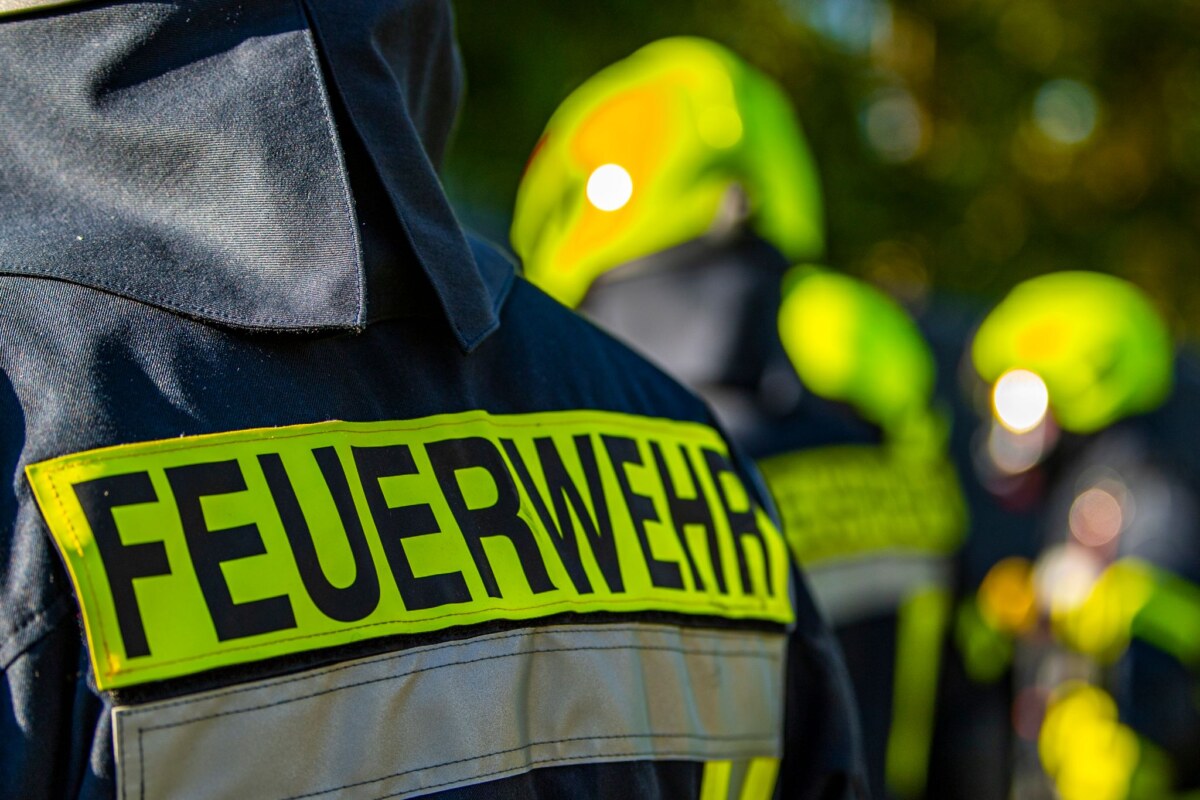 Feuerwehrleute stehen zusammen, um den Einsatz zu besprechen.