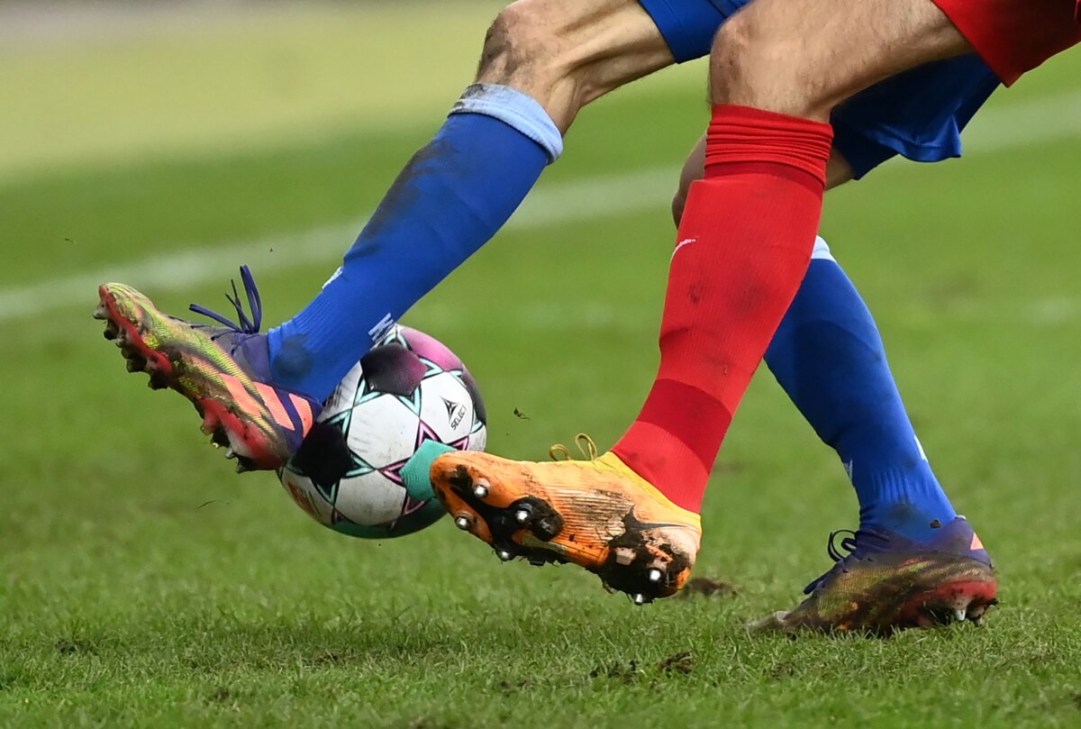 Zwei Fußballspieler kämpfen um den Ball.