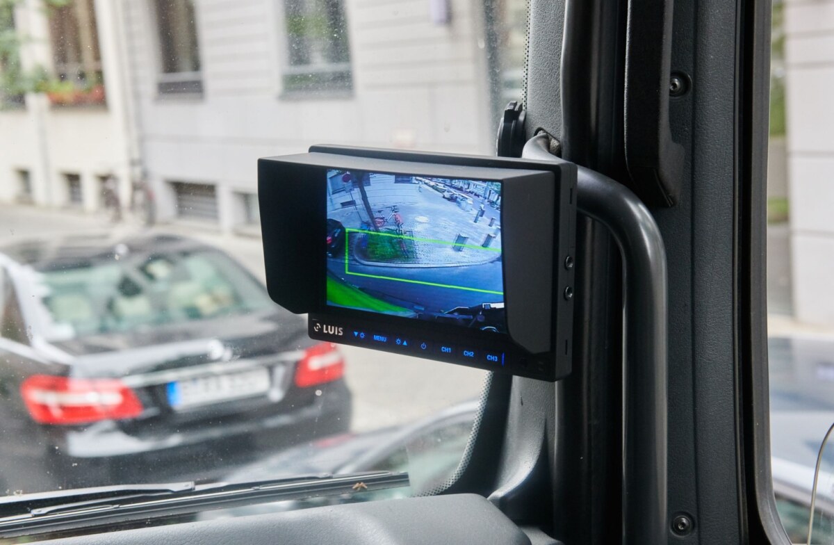 Der Monitor des Abbiegeassistenten eines Lkws zeigt einen grünen Rahmen.