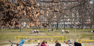 Menschen unterhalten sich auf einer Parkbank.