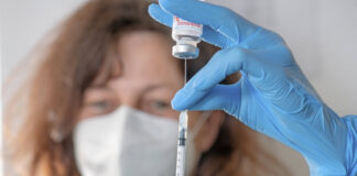 Medizinische Fachangestellte zieht Impfspritze mit Impfstoff Spikevax von Moderna auf