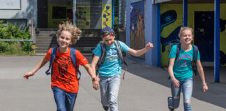 Kinder laufen fröhlich auf einem Schulhof