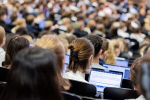 Studentinnen und Studenten sitzen in einem Hörsaal.