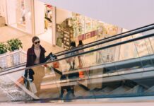 Frau mit Einkaufstaschen auf einer Rolltreppe