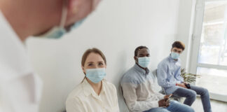 Drei Menschen in einem Arzt-Wartezimmer