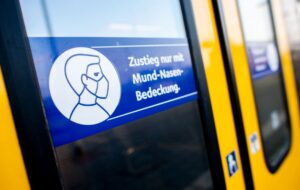 Ein Schild mit der Aufschrift «Zustieg nur mit Mund-Nasen-Bedeckung.» klebt an der Zugtür einer S-Bahn.