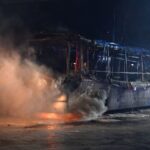 Feuerwehrmänner löschen an der Sonnenallee einen Reisebus, der von Unbekannten angezündet worden war.