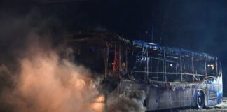 Feuerwehrmänner löschen an der Sonnenallee einen Reisebus, der von Unbekannten angezündet worden war.
