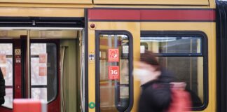 Eine Frau geht an einer S-Bahn vorbei.