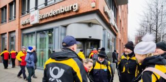 Post-Beschäftigten haben sich vor dem Sitz des Verdi Landesbezirks Berlin-Brandenburg versammelt.
