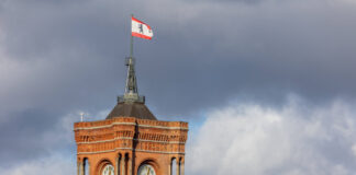 Sonnige Stimmung am Roten Rathaus in Berlin Mitte. 19.02.2023, Berlin, GER - Das Rote Rathaus und Landesflagge in Berlin