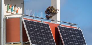 Solarmodule für ein sogenanntes Balkonkraftwerk hängen an einem Balkon.