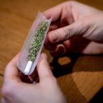 Ein Mann dreht sich einen Joint.