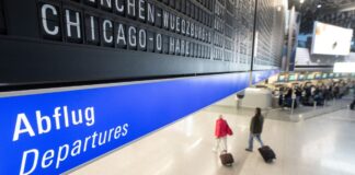 Reisegäste gehen an einem Flughafen zum Abflugterminal.