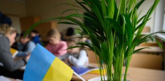 Grundschüler aus der Ukraine sitzen in einem Klassenzimmer.