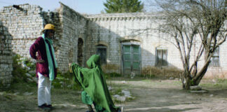 Ein Mann steht vor einer grün gekleideten Person