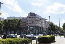 Einkaufszentrum Park Center mit rötlich-hellbrauner Fassade und Glasfronten hinter viel befahrener Kreuzung