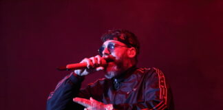 Sido rappt mit Trainingsanzug, Stirnband und Brille in ein Mikrofon. Nur Oberkörper und Kopf zu sehen.