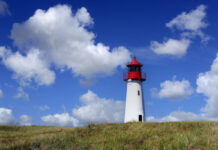 Sylt im Sommer: Der Leuchtturm nahe List mit Schäfchenwolken. Bild: IMAGO/Blickwinkel