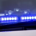 Ein Blaulicht leuchtet unter der Frontscheibe eines Einsatzfahrzeugs der Polizei.