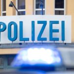 Ein Einsatzwagen der Polizei steht vor einer Dienststelle.