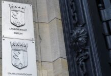 Schilder an der Fassade des Berliner Landgerichts.