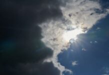 Die Sonne kommt hinter Regenwolken hervor.