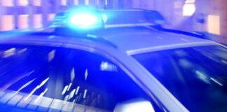 Ein Streifenwagen der Polizei steht mit eingeschaltetem Blaulicht auf der Straße.