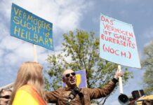 Teilnehmer demonstrieren mit Plakaten im Grunewald bei der Demonstration «my Gruni».