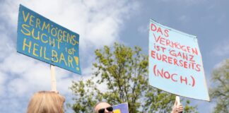 Teilnehmer demonstrieren mit Plakaten im Grunewald bei der Demonstration «my Gruni».