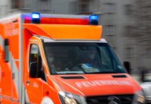 Ein Rettungswagen der Feuerwehr fährt auf einer Straße.