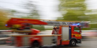 Ein Feuerwehrfahrzeug mit Drehleiter fährt zu einem Einsatz.