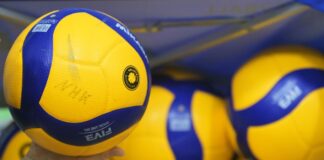 Volleybälle liegen in einer Halle.