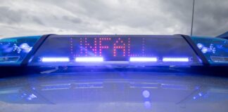 Ein Blaulicht und eine LED-Anzeige leuchten auf dem Dach eines Polizeifahrzeugs.