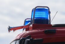 Blaulichter leuchten auf dem Dach eines Einsatzfahrzeugs der Feuerwehr.