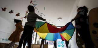Kinder einer Kindergartengruppe der Kita Hoppsala spielen in einem Gruppenraum mit ihrern Erzieherinnen.