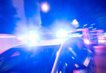 Ein Streifenwagen der Polizei steht mit Blaulicht an einem Einsatzort.