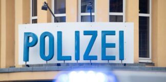 Ein Einsatzwagen der Polizei steht vor einer Dienststelle.