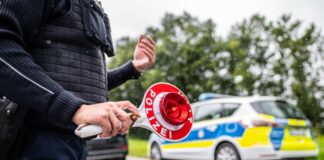 Eine Polizistin hält eine Winkerkelle in der Hand.