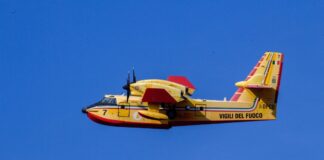 Ein Löschflugzeug fliegt am blauen Himmel.