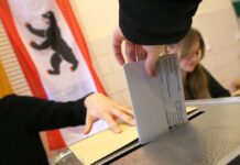 Eine Frau gibt ihre Stimme für die Wahl zum Berliner Abgeordnetenhaus ab und wirft ihren Wahlzettel in die Wahlurne.